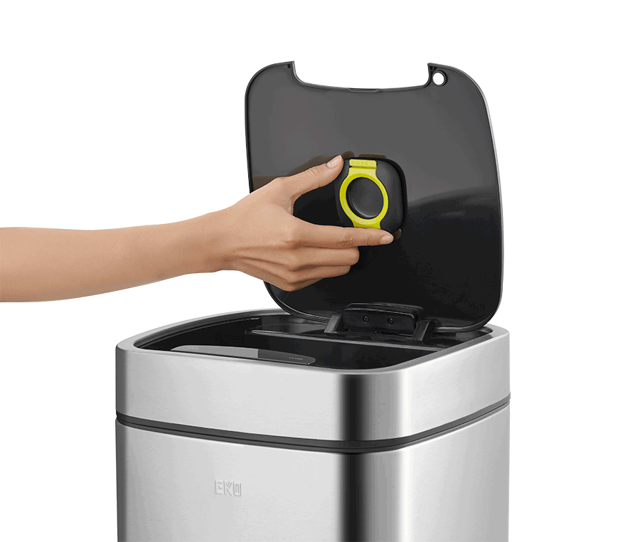 A person opening the lid of a stainless steel trash can, revealing it to be a Perfume Capsule Holder.